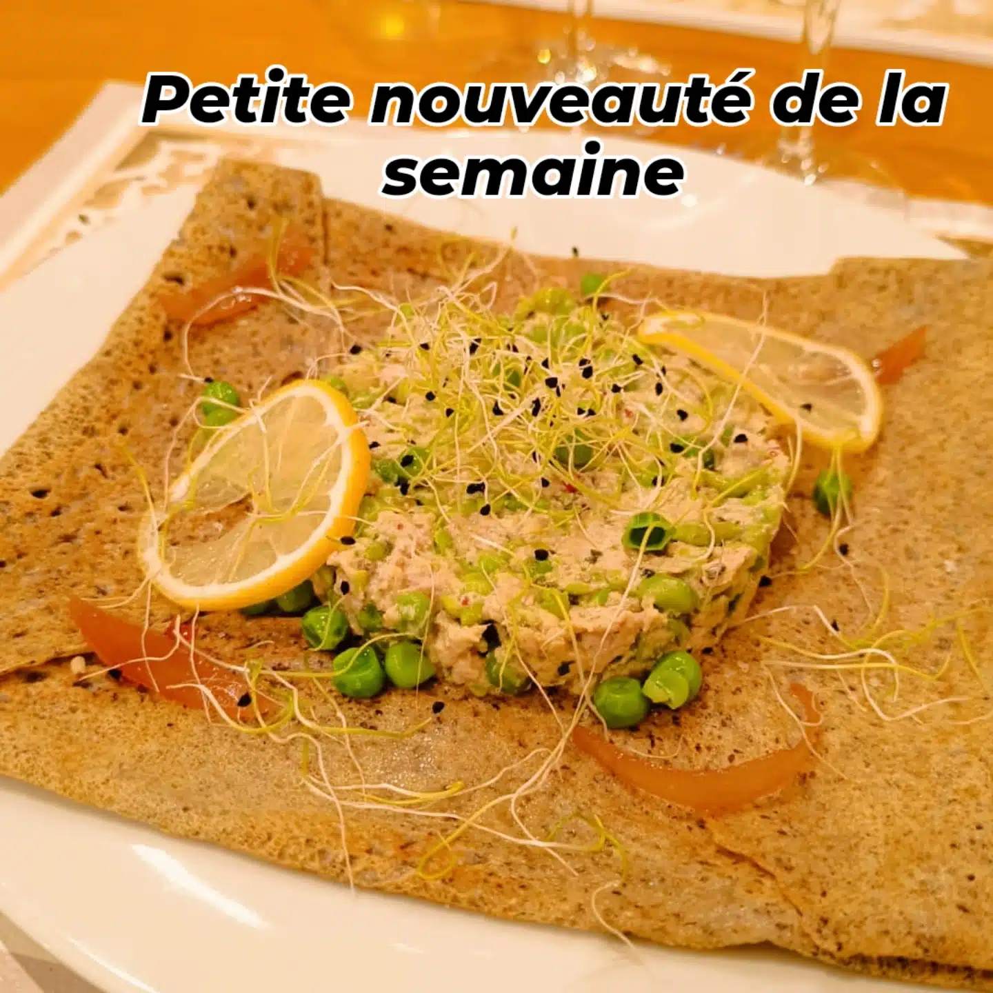 Galette de sarrasin garnie d'une préparation au thon et petits pois, décorée de citron et germes. Texte: Petite nouveauté de la semaine.