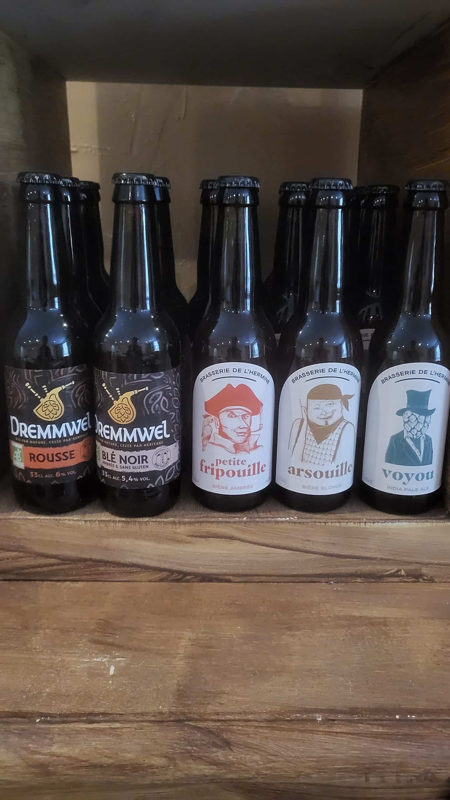 Cinq bières artisanales: Dremmwel Rousse (6%), Blé Noir (5.4%) et Brasserie de l'Hermine (Petite Fripouille, Arsouille, Voyou) sur étagère en bois.