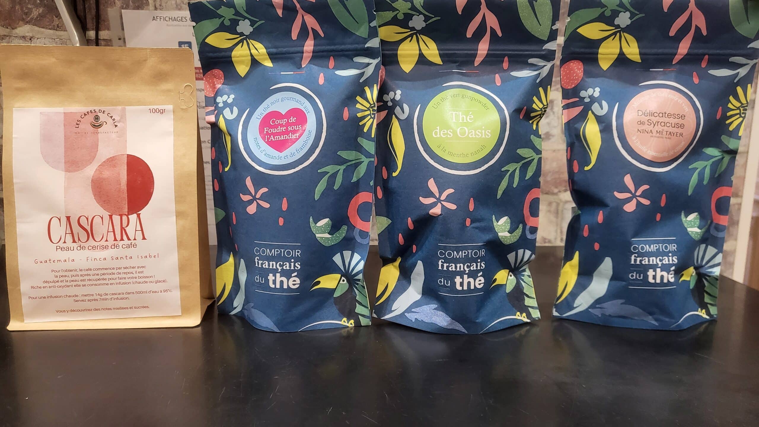 Quatre emballages de produits: Cascara Les Cafés de Carla, Coup de Foudre sous l'Amandier, Thé des Oasis, et Délicatesse de Syracuse Comptoir français du thé.